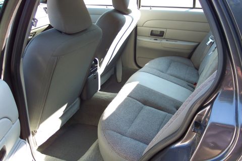 2001 Ford Crown Victoria - The interior of a car, likely a 2003 model, with gray cloth seats and a beige door panel.