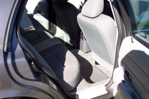 2001 Ford Crown Victoria - The interior of a car is shown, focusing on the rear seating area and the open rear door.