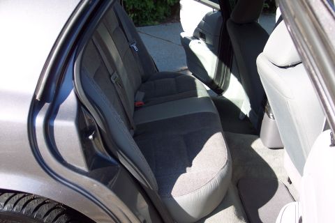 2001 Ford Crown Victoria - Interior view of a car's rear seating area, showing fabric seats and floor mats.