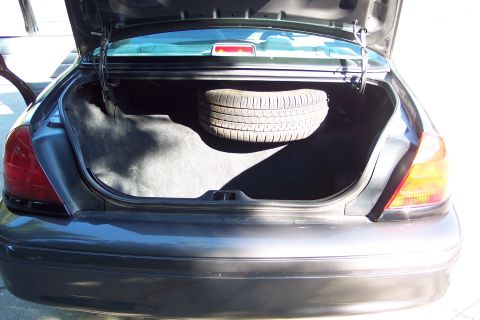 2001 Ford Crown Victoria - The trunk of a 2001 Ford Crown Victoria is open, revealing a spare tire and the car's interior.