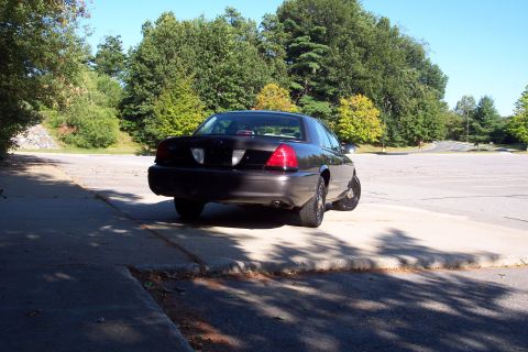 2001 Ford Crown Victoria - Rear view of a dark 2001 Ford Crown Victoria parked in an outdoor lot.