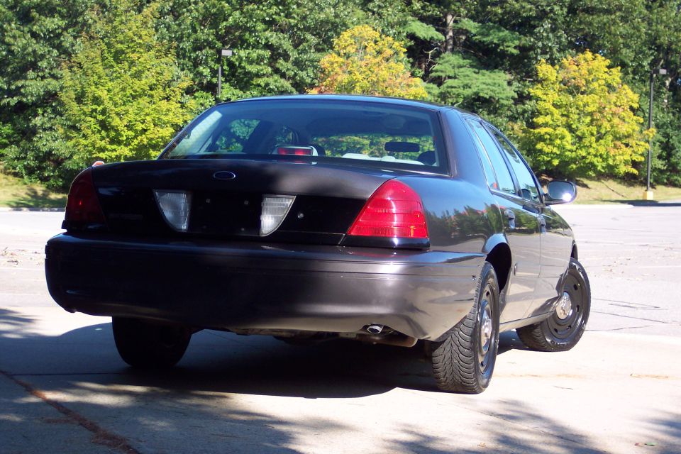Rear view of black Ford Crown Victoria Police Interceptor. Has steel wheels and police-style tires