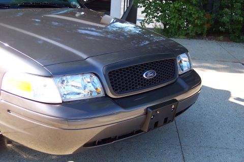 2001 Ford Crown Victoria - Front view of a gray 2001 Ford Crown Victoria, its distinctive honeycomb grille and Ford emblem.