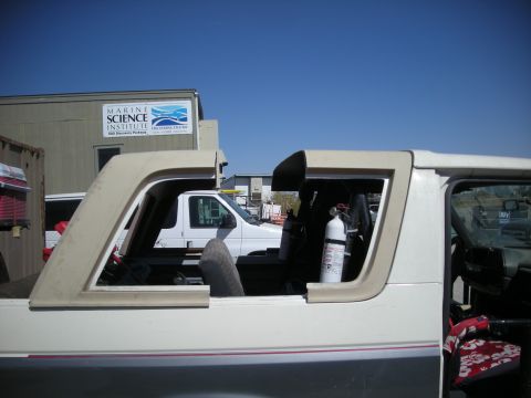 1991 Ford Bronco - A white van is visible behind a white SUV that appears to be undergoing some work.