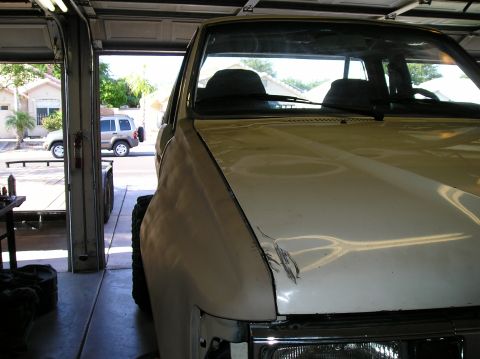 1986 Toyota Hilux - Front view of a 1986 Toyota Hilux parked in a garage with another vehicle outside.