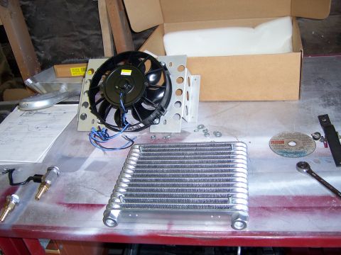 1991 Ford Bronco - A transmission cooler and fan are laid out on a workbench, suggesting an automotive repair or upgrade.