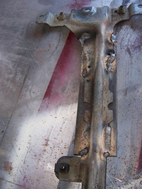 1991 Ford Bronco - A close-up view of a welded metal bracket, likely a component from a vehicle's transmission cooler system.