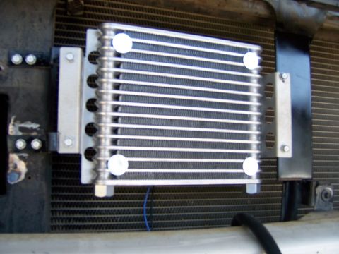 1991 Ford Bronco - An aftermarket transmission cooler is installed in front of the main radiator, secured by metal brackets.