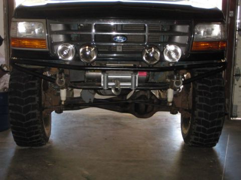 1995 Ford Bronco - Frontal view of a 1995 Ford Bronco, an aftermarket bumper with a winch and auxiliary lights.