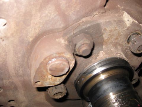 1995 Ford Bronco - Close-up view of a rusty ball joint assembly, showing bolts and a metal shaft.