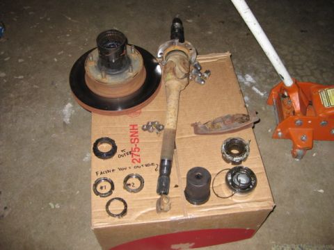 1995 Ford Bronco - Various vehicle components, including an axle shaft and brake rotor, are arranged on a cardboard box.