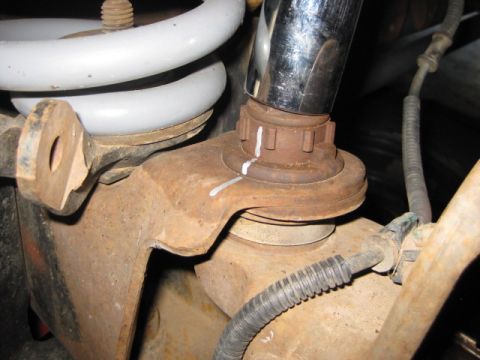 1995 Ford Bronco - Close-up of a vehicle's suspension system, showing a ball joint assembly and coil spring.