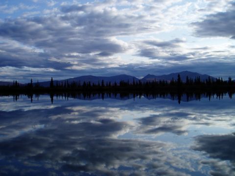 2000 Ford E350 - A landscape captures the reflection of a dramatic sky and silhouetted trees in a calm lake.