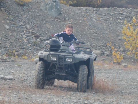2000 Ford E350 - Young rider on an all-terrain vehicle in a rocky, outdoor setting.
