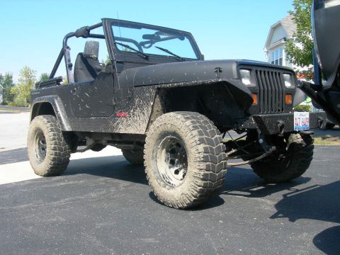 1991 Jeep Wrangler - This Jeep Wrangler is covered in mud, suggesting it has been off-roading recently.