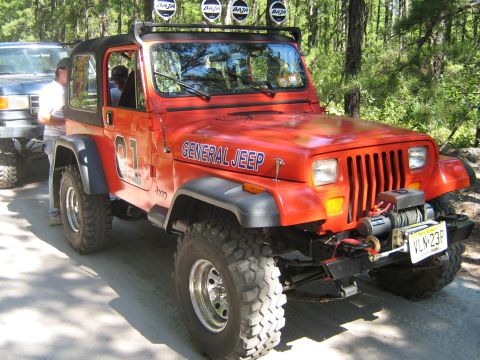 1990 Ford Bronco - This orange Jeep Wrangler features "General Jeep" text and the number "01" on its side, along with a front winch and Baja lights.