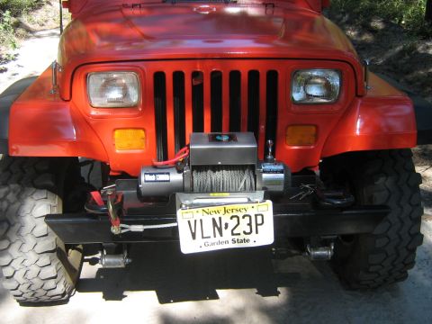 1990 Ford Bronco - Front view of a red Jeep Wrangler, equipped with a winch and aftermarket bumper.