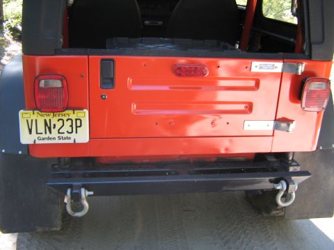 1990 Ford Bronco - Rear view of an orange Jeep Wrangler, a New Jersey license plate and an aftermarket bumper.