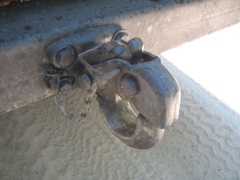 1990 Ford Bronco - Close-up of a tow hitch and safety chain on a vehicle's frame.