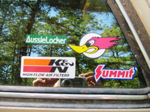 1990 Ford Bronco - A vehicle window displays several aftermarket stickers, including K&N High-Flow Air Filters, Summit Racing, AussieLocker, and a Road Runner…