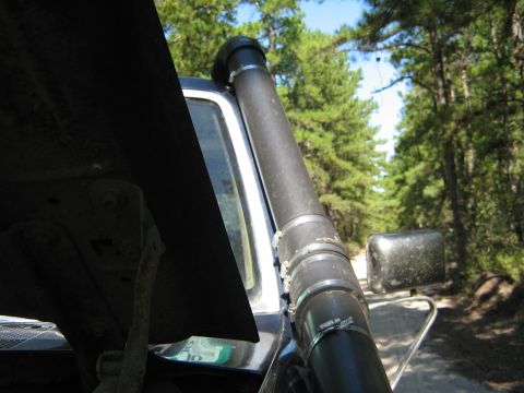 1990 Ford Bronco - A 1990 Ford Bronco is equipped with a snorkel, seen from the side with a wooded background.