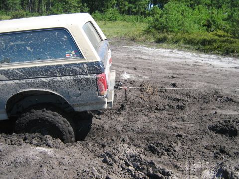1990 Ford Bronco - This 1990 Ford Bronco is deeply stuck in mud, with a winch cable attached to its rear bumper.