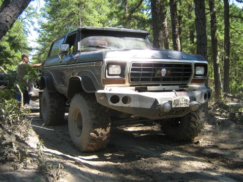 1990 Ford Bronco - This heavily modified 1978 Ford Bronco navigates a wooded trail with its large tires and custom bumper.