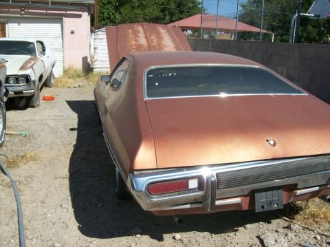 1975 Ford Ranchero - Rear view of a 1975 Ford Ranchero with its hood open, parked next to another vehicle.