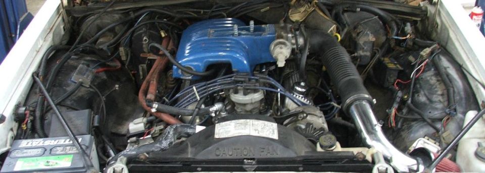 Engine bay with blue-painted intake plenum, blue plug wires and Interstate battery