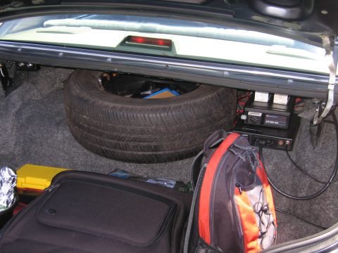 2001 Ford Crown Victoria - The trunk of a car contains a spare tire, luggage, and electronic equipment.