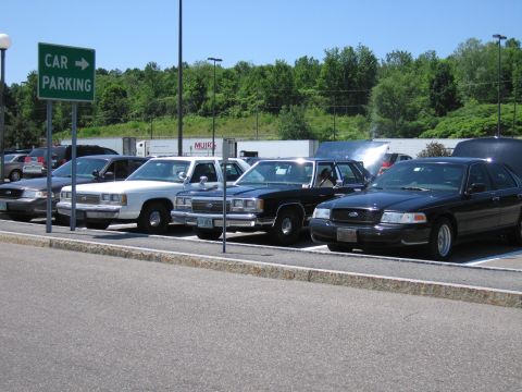 2001 Ford Crown Victoria - Several Ford Crown Victoria police sedans are parked in a lot under a clear sky.