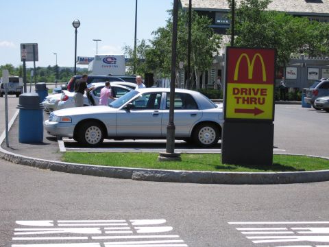 2001 Ford Crown Victoria - A silver 2001 Ford Crown Victoria is parked in a lot next to a McDonald's drive-thru sign.