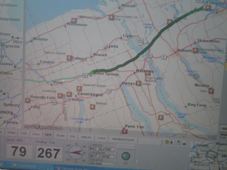 GPS screen displaying a map of New York State with a route highlighted, speed 79 MPH, distance 267 miles, and GPS coordinates