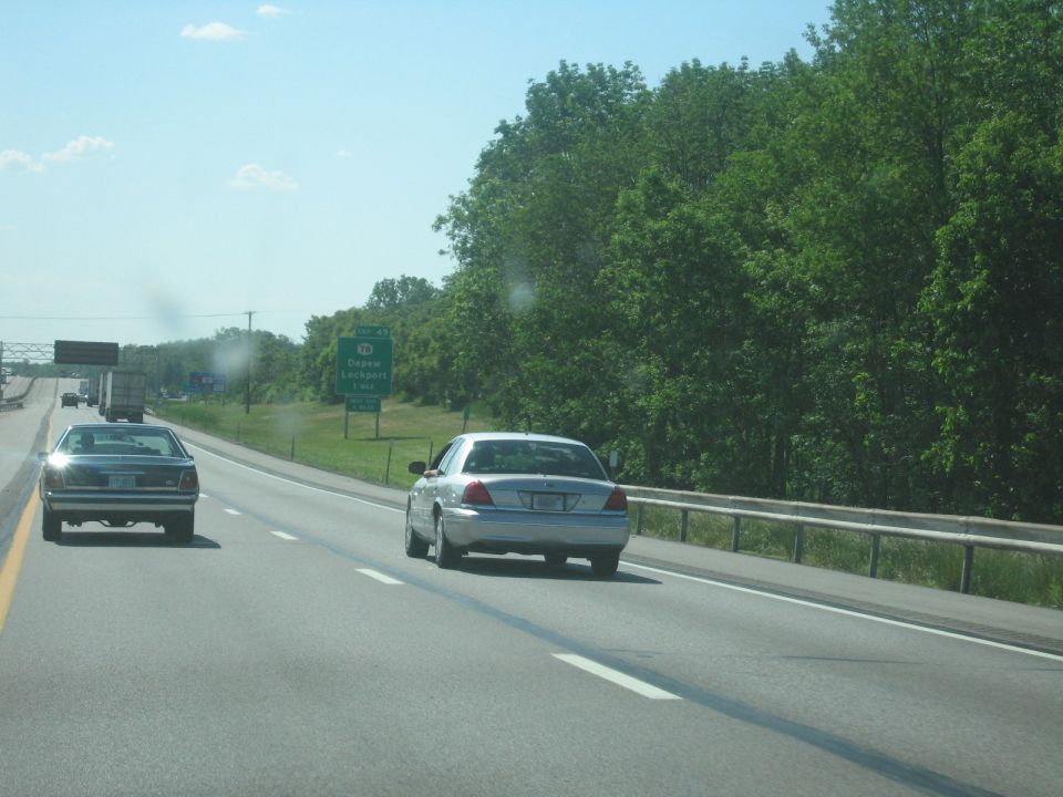 Silver 2001 Ford Crown Victoria and a dark sedan on a highway