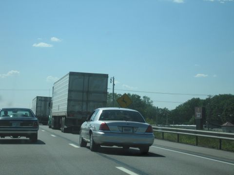 2001 Ford Crown Victoria - A silver 2001 Ford Crown Victoria travels down a highway behind a semi-truck.