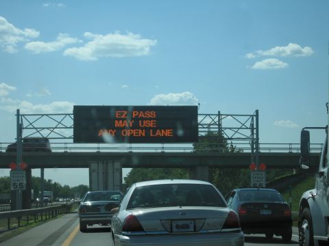 2001 Ford Crown Victoria - A silver 2001 Ford Crown Victoria is seen from behind on a highway, with an overhead electronic sign displaying traffic information.