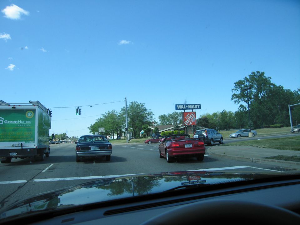 Rear view of a dark sedan on a sunny day