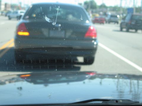 2001 Ford Crown Victoria - Driving behind a black 2001 Ford Crown Victoria on a sunny day, with other cars visible.