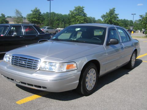 2001 Ford Crown Victoria - A silver 2001 Ford Crown Victoria sedan is parked in a lot on a sunny day.