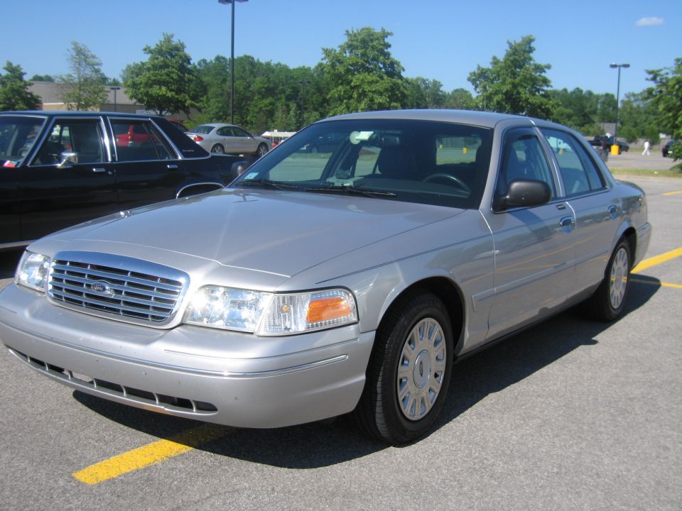 Silver 2001 Ford Crown Victoria sedan parked in a lot, front 3/4 view