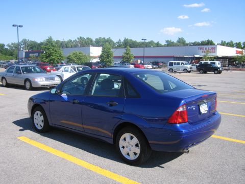 2001 Ford Crown Victoria - Blue Ford Focus sedan parked in a lot with a silver Crown Victoria nearby.