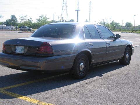 2001 Ford Crown Victoria - A 2001 Ford Crown Victoria is parked in a lot, seen from the rear three-quarter angle.