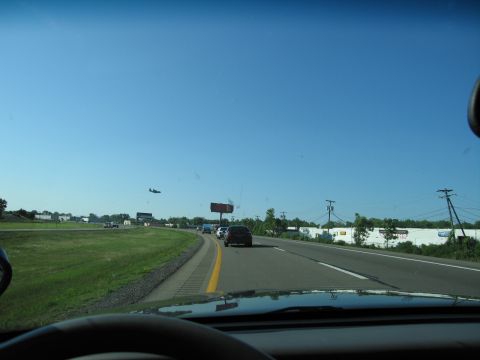 2001 Ford Crown Victoria - Driving on a highway with other vehicles and a plane in the sky.