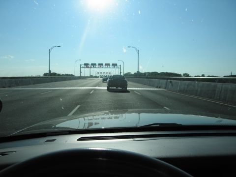 2001 Ford Crown Victoria - Driving on a highway with a dark sedan in front, approaching overhead signs.
