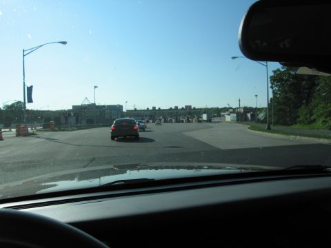2001 Ford Crown Victoria - Vehicles approach a toll plaza under a bright blue sky, with construction barriers visible on the left.