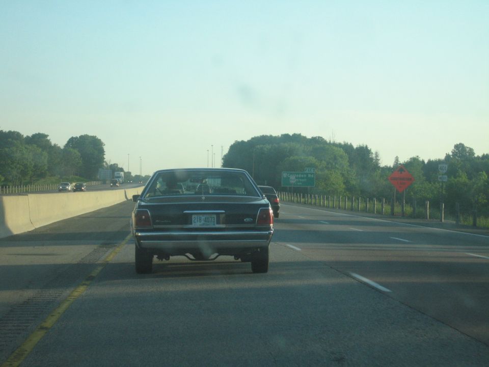 2001 Ford Crown Victoria driving on highway, rear view. License plate 218-4073