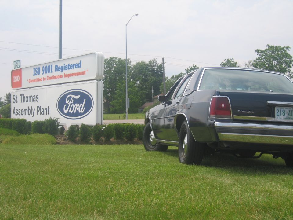 Dark 2001 Ford Crown Victoria rear view parked on grass
