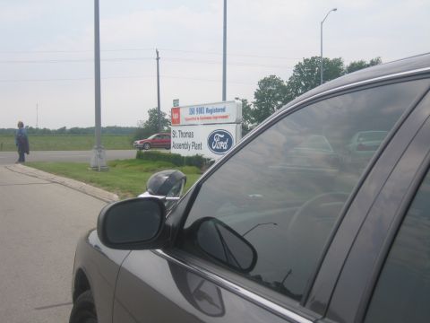 2001 Ford Crown Victoria - The Ford St. Thomas Assembly Plant sign is visible, with a person and cars reflected in a nearby vehicle.