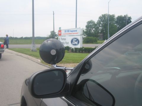 2001 Ford Crown Victoria - A police car with a spotlight is parked near a sign for the St. Thomas Assembly Plant.
