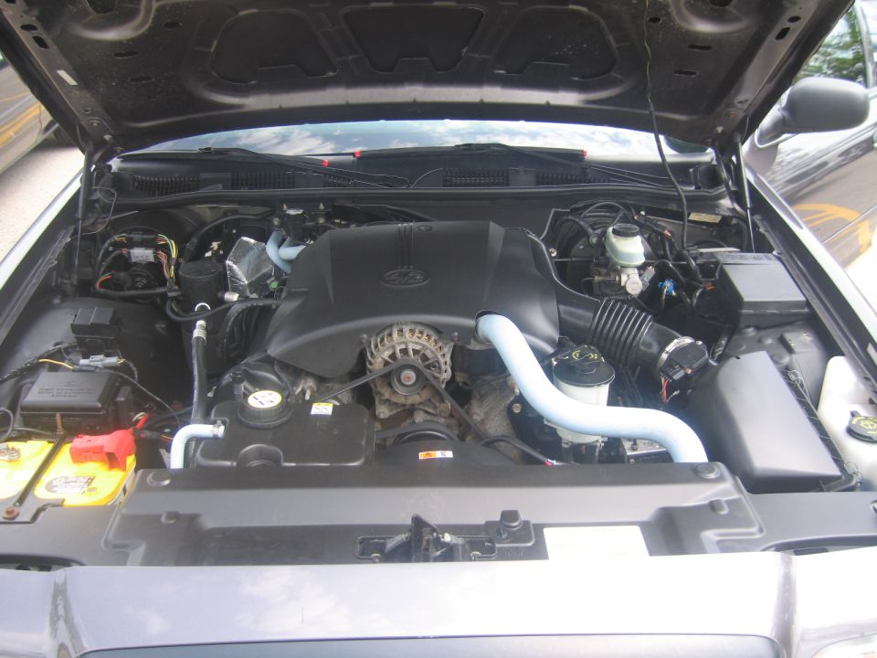 2001 Ford Crown Victoria engine bay with hood open, showing engine components and battery
